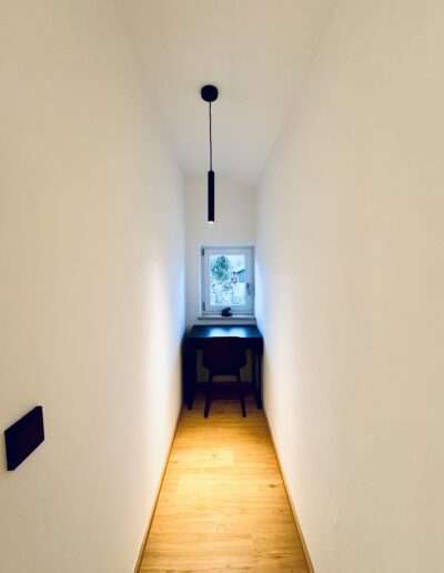 Gang mit Schreibtisch und Designerlampe