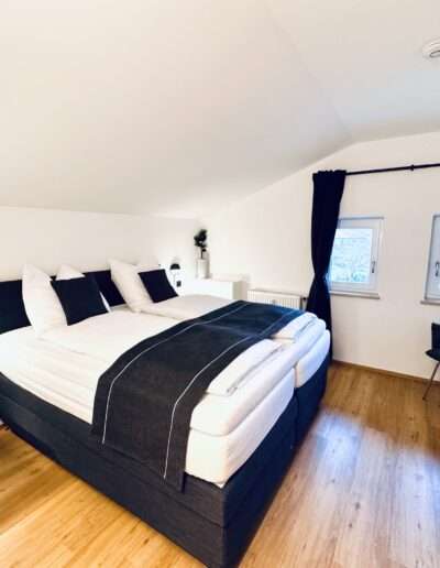 Schlafzimmer mit Kofferablage, Stuhl und Nachttischen