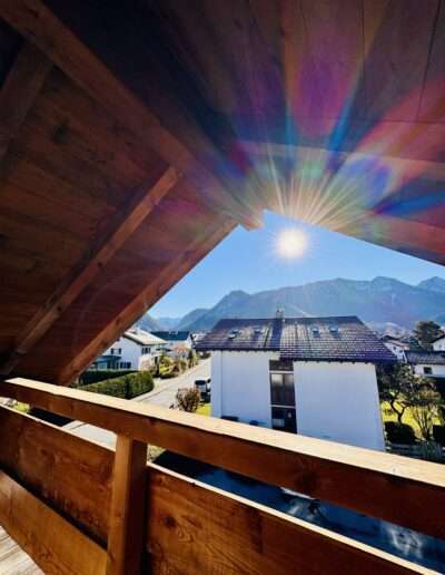 Ausblick mit Sonne vom Balkon auf die Chiemgauer Alpen